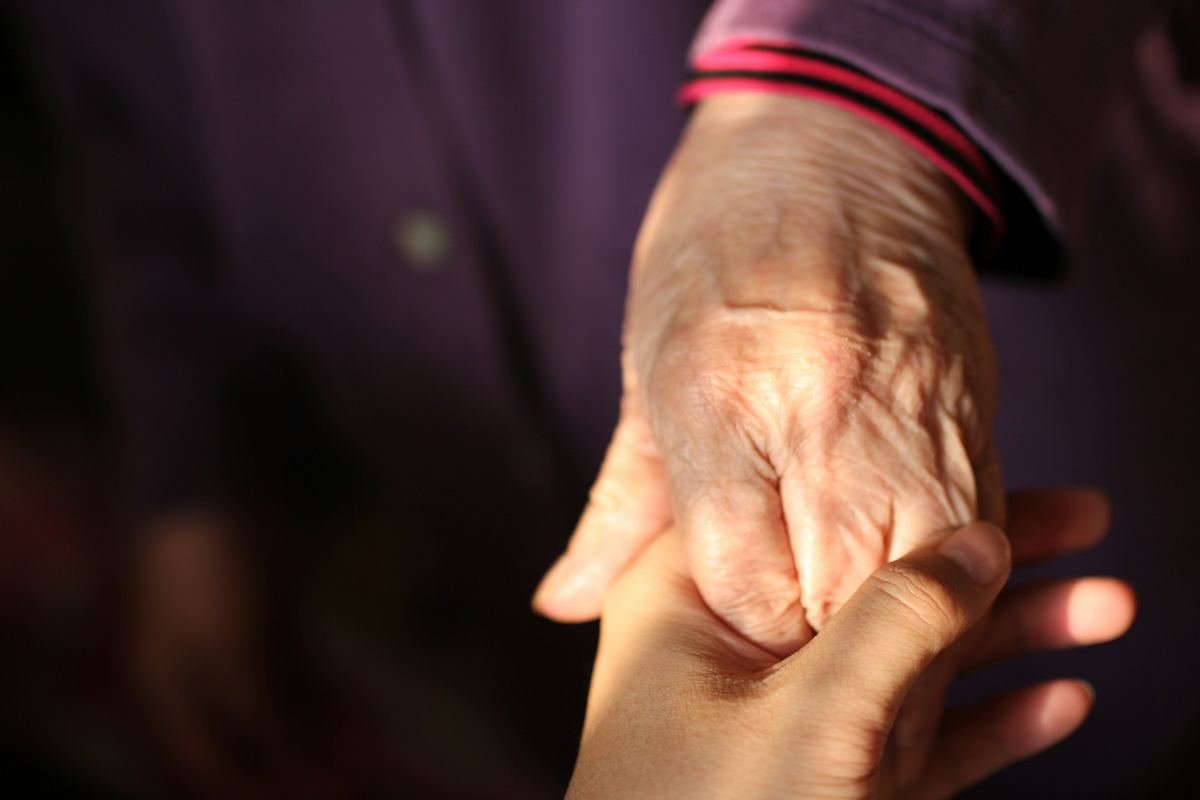 Two hands joined in soft warm light.
