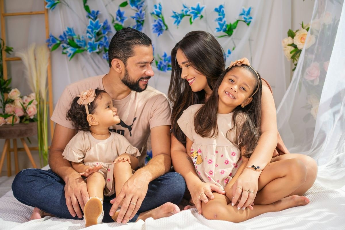 A family of four sitting together and smiling.