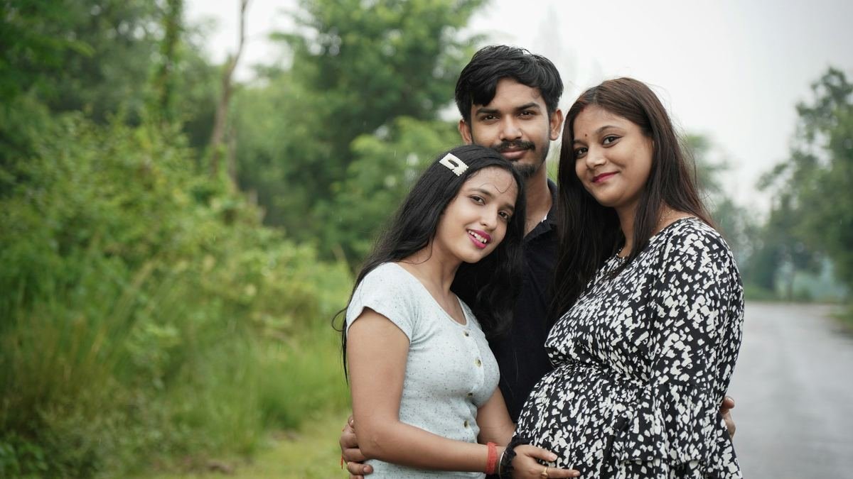 A young family standing together outdoors.