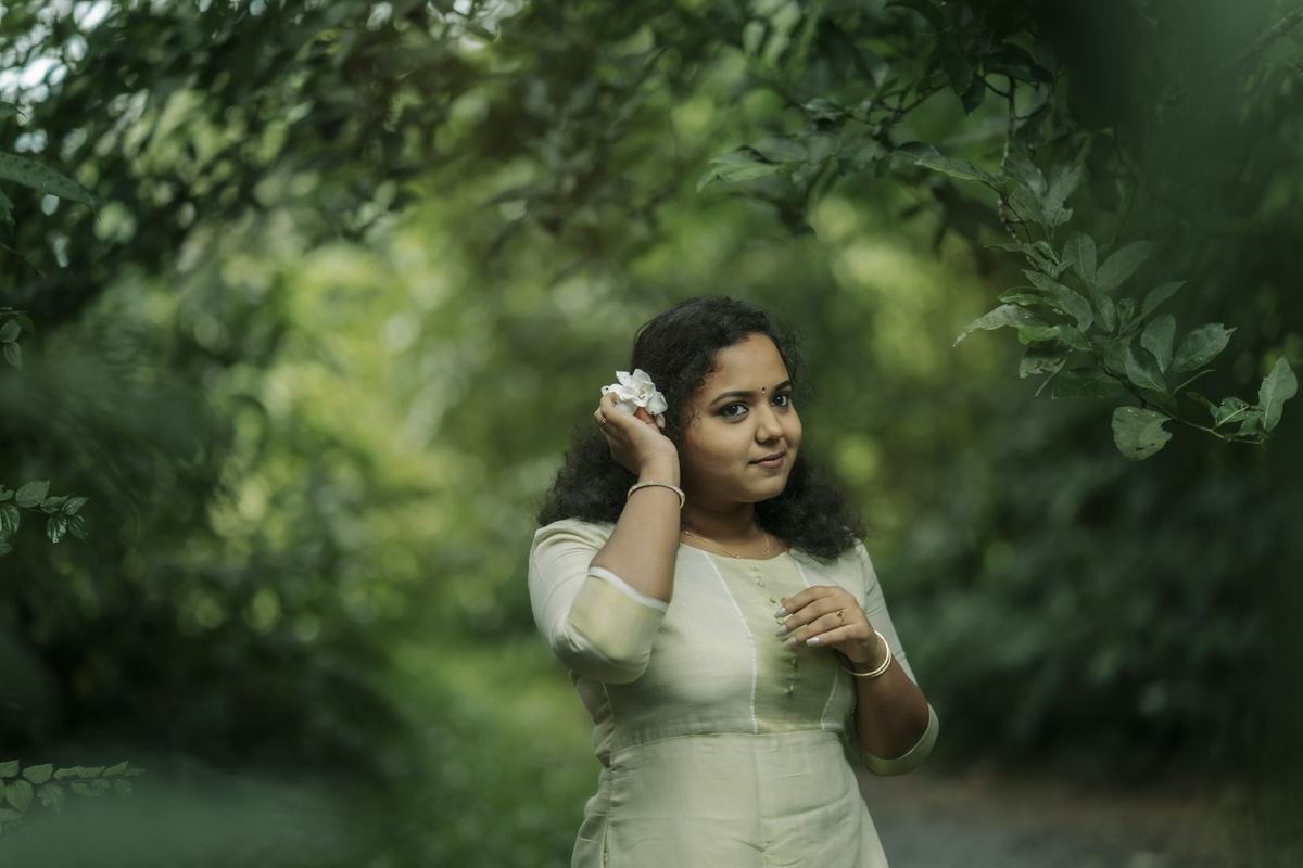 A young woman standing in a green garden.