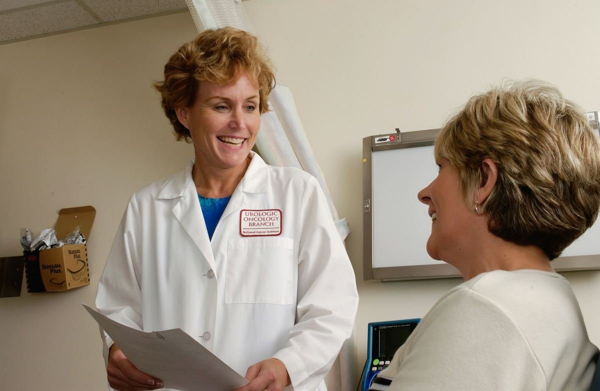 A doctor smiling as she talks with a patient in a clinic.
