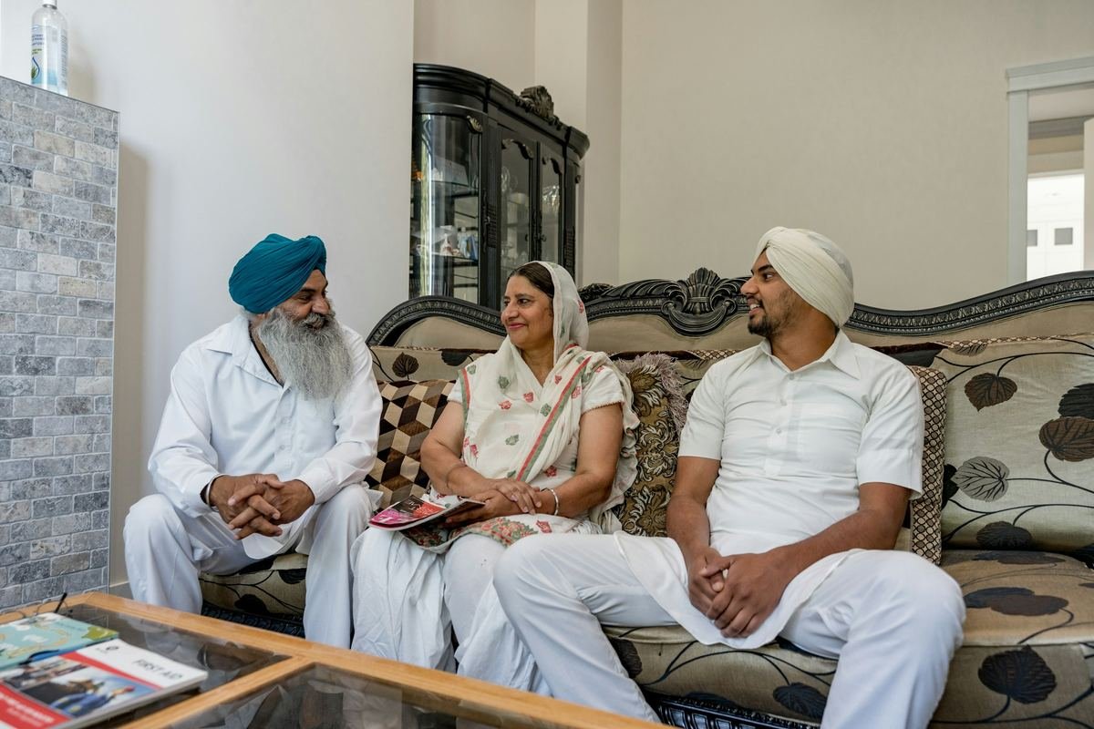 A family sitting together and talking in a light, modern living room.