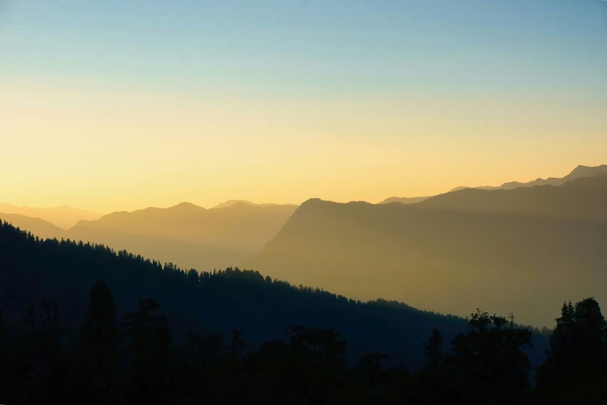 Golden light over layered mountains.