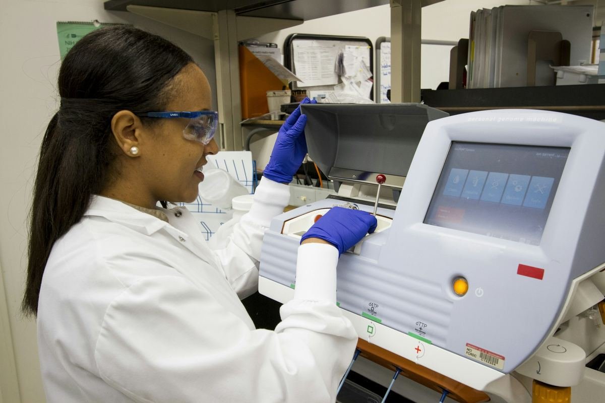 A laboratory technician loading samples into a genomic sequencing instrument.