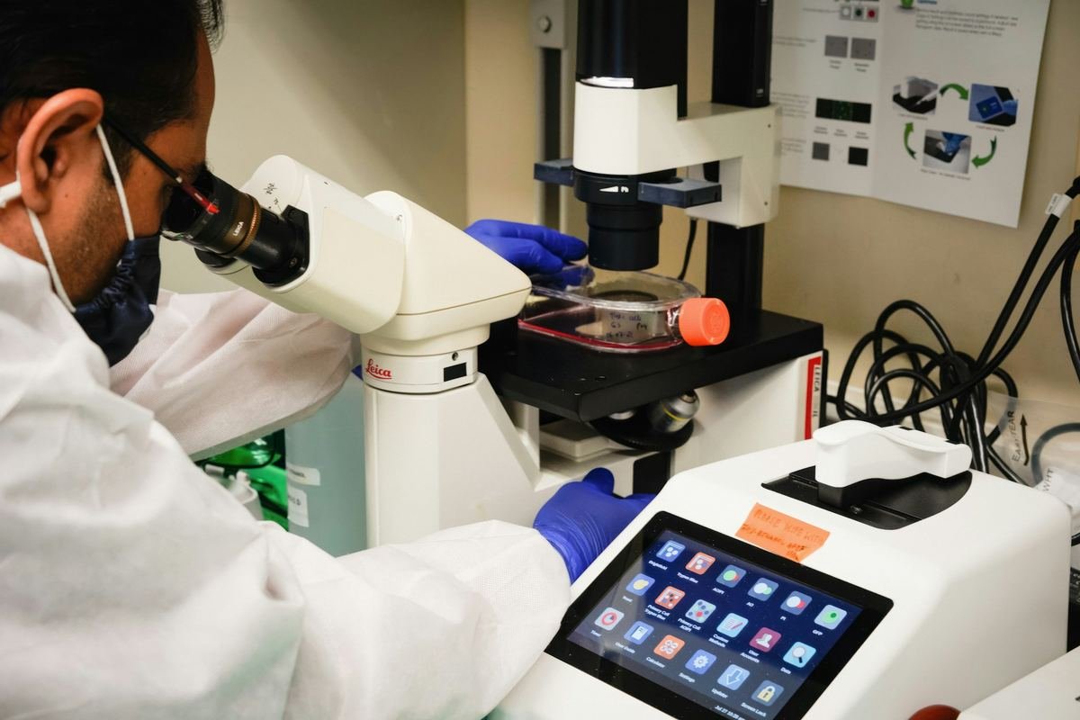 A scientist looking through a microscope in a laboratory.