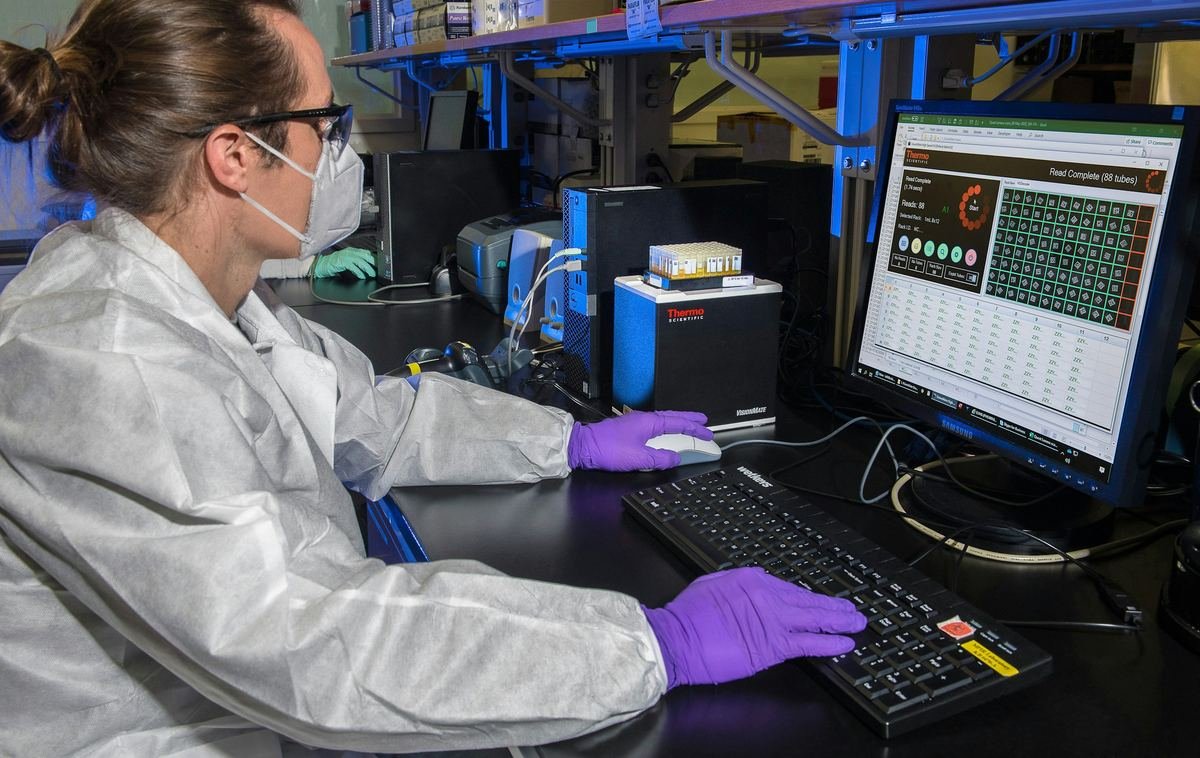 A laboratory scientist entering results at a computer.