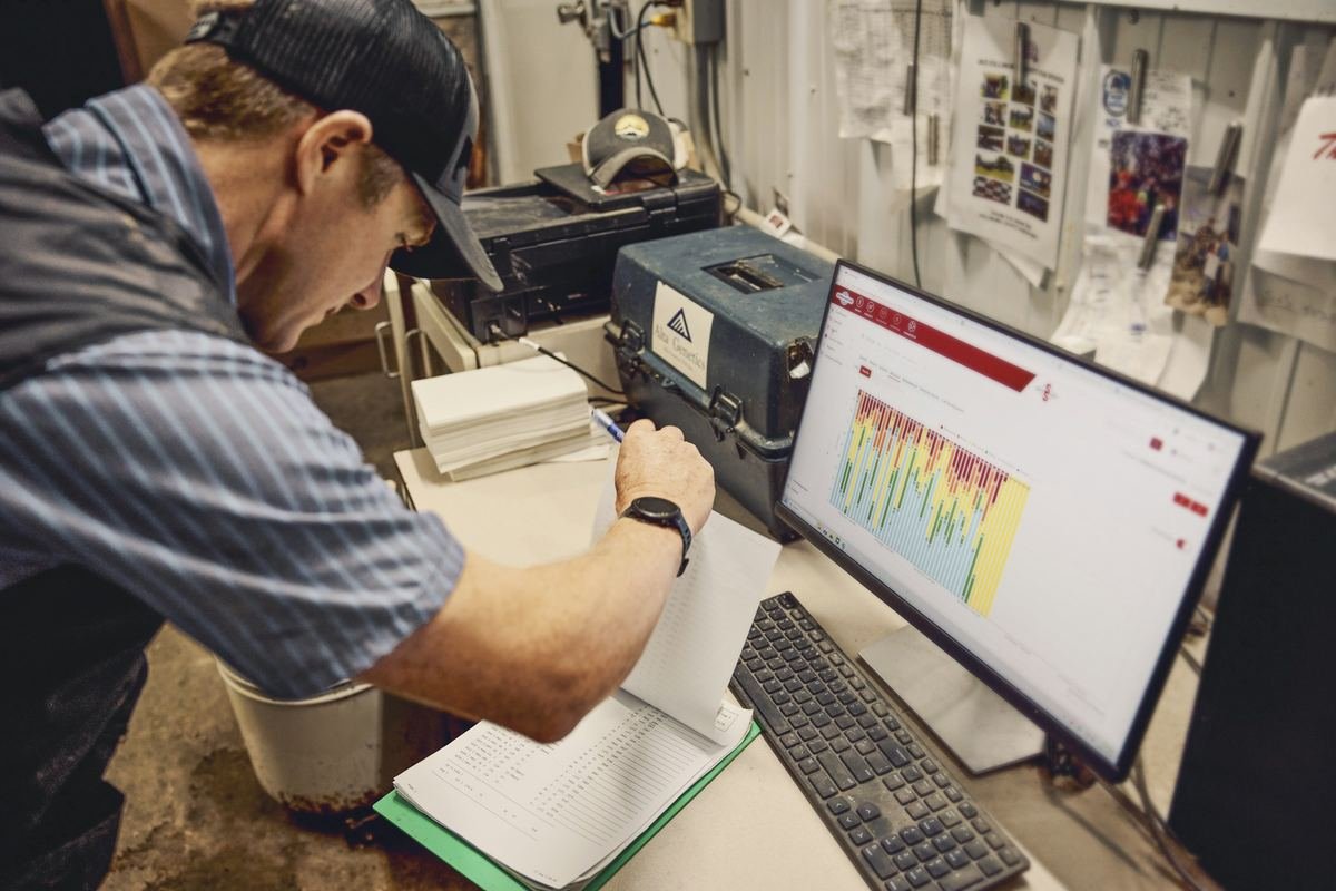 A researcher reviewing data charts beside laboratory equipment.